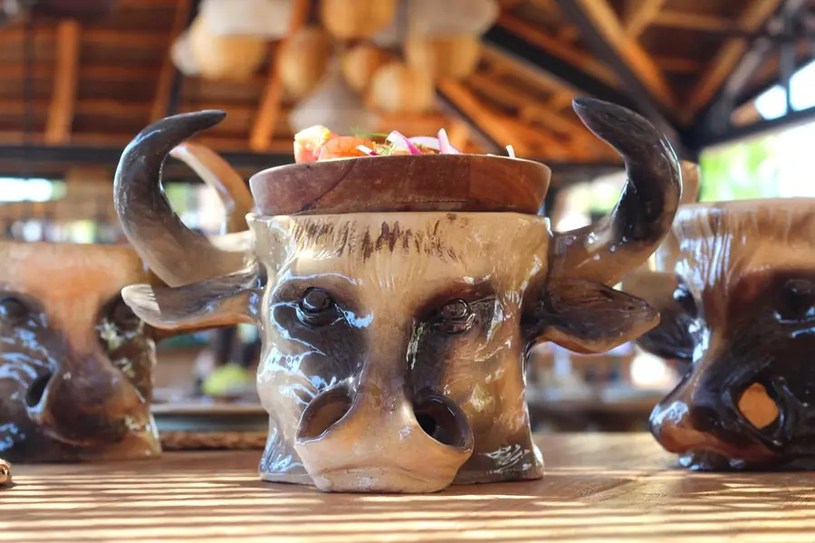Varias tazas cerámicas de cabeza de toro servidas en la mesa del restaurante Boca Pez