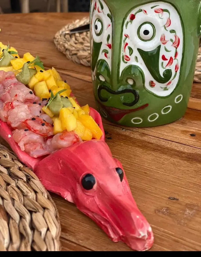 Fuente cerámica de pescado con ceviche y mango junto a una taza esculpida, Boca Pez