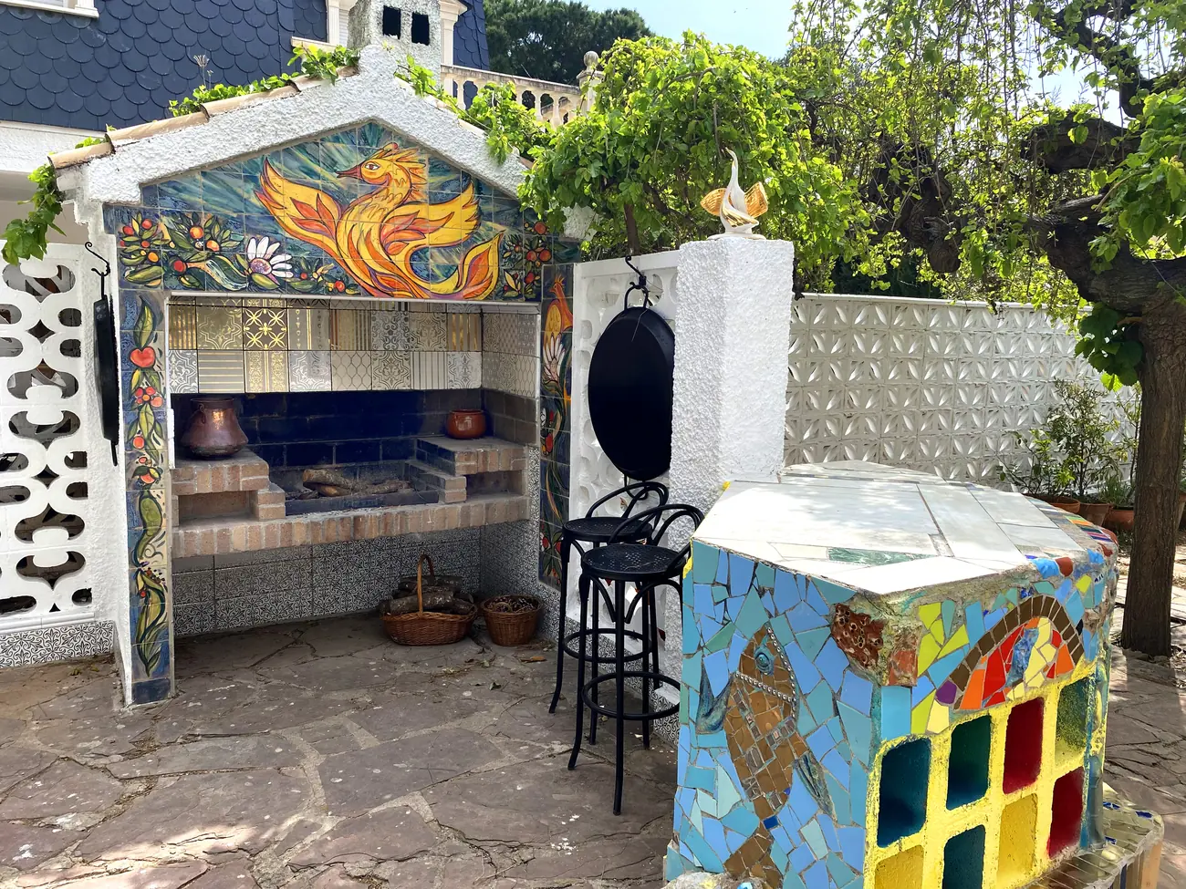 Barbacoa de jardín revestida de cerámica con un ave de fuego dorada pintada a mano en el frontón